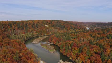 Wunderschöne-Herbstfarben:-Drohnenaufnahme-Eines-Flusses-Mit-Kleinen-Inseln,-Der-Im-Herbst-Durch-Einen-Farbenfrohen-Wald-Führt