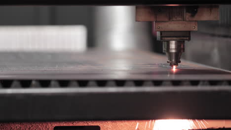 Metal-Working---Plasma-Laser-Cutting-Technology-Of-Flat-Sheet-Metal-Material-With-Sparks-Underneath---close-up,-slow-motion