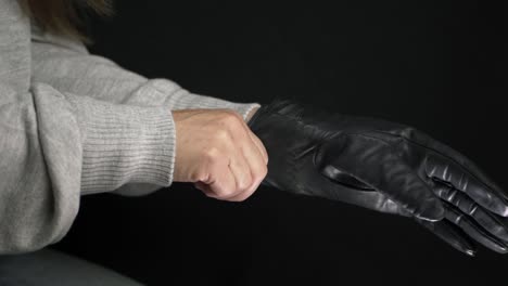 Hände,-Die-Schwarze-Fahrhandschuhe-Anziehen,-Mittlere-Aufnahme-Auf-Schwarzem-Hintergrund
