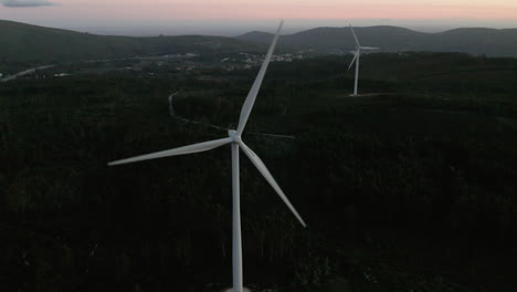 Grandes-Turbinas-Eólicas-Con-Hélice-Que-Gira-Lentamente-Durante-La-Puesta-De-Sol-En-Serra-De-Aire-E-Candeeiros,-Leiria-Portugal