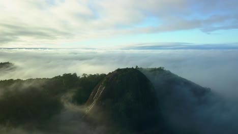 Voltzberg-granite-dome-mountain-in-misty-Suriname-jungle-rainforest,-aerial-view