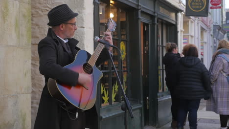 Ein-Straßenmusikant-Spielt-Musik-Auf-Der-Straße-Von-Truro,-England,-Und-Unterhält-Die-Menschen-–-Totale