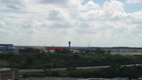 Wide-rising-aerial-establishing-view-of-Luton-Airports-Air-Traffic-Control-tower-and-grounded-aircraft-during-the-coronavirus-pandemic