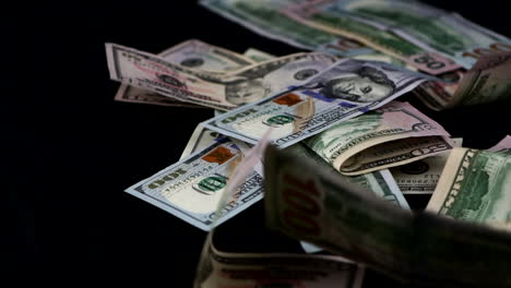 Stack-Of-United-States-Dollar-Bills-Falling-On-Scattering-On-Black-Surface