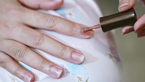 Closeup-of-a-woman-paints-her-nails-by-self-made-manicure-at-home-slow-motion-scene