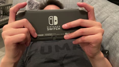 Mann,-Der-Nintendo-Switch-Spiele-Spielt,-Während-Er-Auf-Der-Couch-Liegt