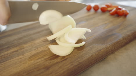 Chopping-onions-on-a-wooden-cutting-board