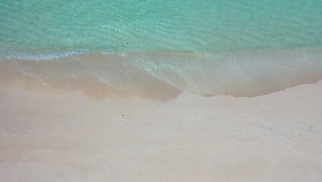 Clear-water-of-shallow-turquoise-lagoon-washing-gently-unspoiled-fine-sand-of-exotic-beach,-copy-space-with-sea-texture,-Bermuda