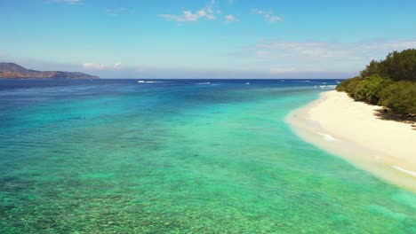 Paradise-exotic-beach-of-tropical-island-with-white-sand-washed-by-blue-sea-and-turquoise-lagoon-with-crystal-emerald-water-in-Philippines