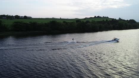 Slow-Motion-Aerial-of-Water-Skier-and-Tow-Speed-Boat-in-Afternoon-on-River-Bann