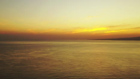 Goldener-Sonnenuntergang-Mit-Gelben-Wolken-Und-Hellem-Himmel,-Der-Sich-Auf-Der-Friedlichen,-Endlosen-Meeresoberfläche-In-Kambodscha-Spiegelt,-Kopierraum
