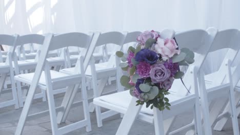 Back-side-view-of-white-chairs-in-a-row-in-a-big-hall-for-wedding