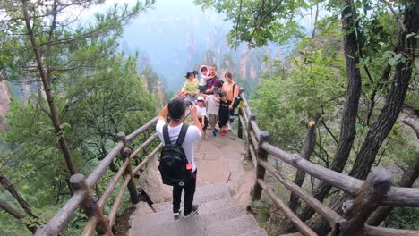 Chinese-family-taking-group-picture-on-mobile-phones-on-the-viewpoint-in-Tianzi-mountain-range,-Avatar-mountains-nature-park