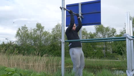 Man-Goes-In-For-Sports-Doing-Pull-up-Exercises-On-DIY-Horizontal-Bars---wide-shot