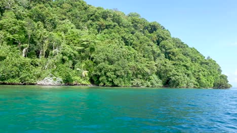 A-tropical-island-paradise-and-turquoise-green-blue-water-from-a-boat-in-Bougainville,-Papua-New-Guinea