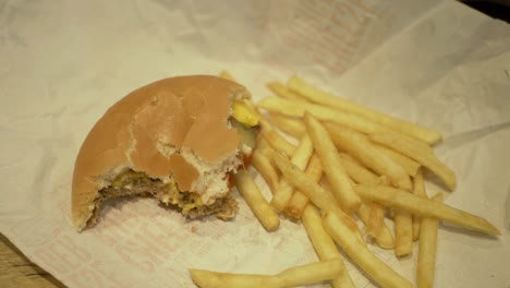 Burger-Und-Pommes-Zur-Hälfte-Aufgegessen,-Mittlere-Schwenkaufnahme