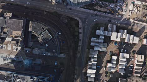 Rising-drone-shot-of-road-junction-near-DLR-train-tracks-canary-wharf-London