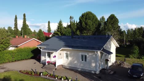 Ascend-aerial-shot-of-beautiful-cottage-in-rural-park-area-during-sunny-day-in-Haapajarvi,Finland