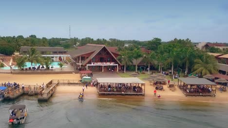 Cinematic-reverse-drone-shot-of-Aqua-Safari-Resort-beach-front-with-boats