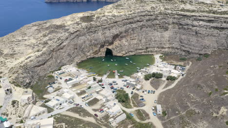 Schiffe,-Die-Vom-Stadthafen-Aus-Fahren,-Dwerja-Höhle-In-Einer-Felswand,-Malta,-Luftaufnahme