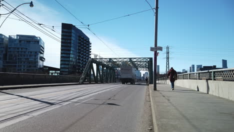 Wide-shot-of-Queen-Street-truss-bridge-with-passing-traffic-and-pedestrian