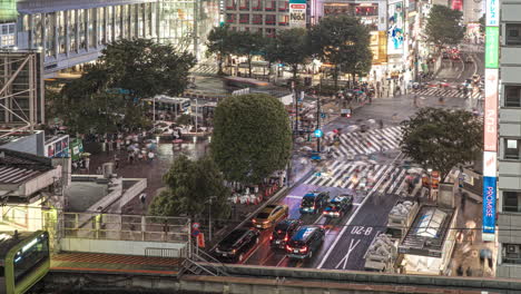 Tráfico-En-El-Cruce-De-Shibuya-Con-Peatones-Por-La-Noche-En-Tokio,-Japón