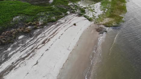 white-sand-beach-vegitation-waves-washing-ashore-tybee-island-georgia-aerial-drone