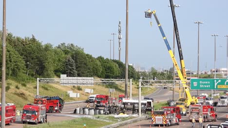 Wide-shot-of-oil-truck-accident-on-highway-during-sunny-day---fire-department-working-with-Crane-and-cleaning-road---oil-pollution-of-nature