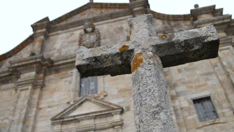 Christian-cross-in-front-of-the-royal-monastery-of-Santa-Maria-de-Oia-in-the-portuguese-way-of-saint-james-in-the-atlantic-coast-in-Galicia