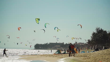 Beach-full-of-colorful-kites-flying-in-a-blue-sky