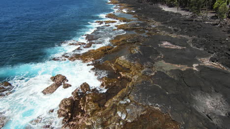 FPV-slomo-drone-shot-over-blue-ocean-crashing-on-basalt-shoreline