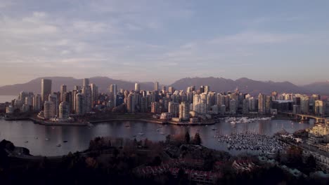 Aerial-panoramic-view-of-Vancouver-city-with-mountains-in-background-at-sunset,-Canada