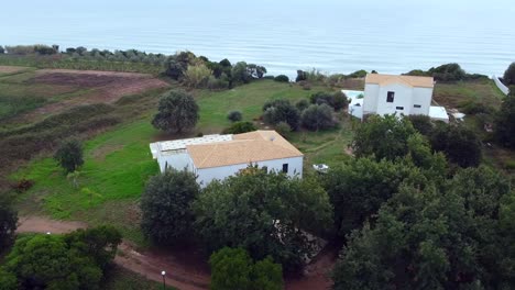 Great-aerial-drone-flight-panorama-curve-flight-drone-shot-around-a-finca-house-and-boat-on-cliff