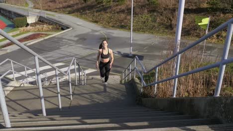 Athletic-young-woman-running-up-steps-Slow-motion-wide-shot