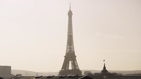 Eiffelturm-Teleobjektiv-Mit-Langer-Linse,-Aufgenommen-Mit-Französischer-Flagge,-Die-Im-Wind-In-Zeitlupe-4k-30p-Weht