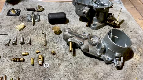 A-dismantled-carburettor-from-VW-campervan-restoration-project-laid-out-and-ready-to-be-cleaned-in-GT-Sonic-ultrasonic-chemical-cleaning-device,-shot-panning-out