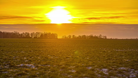Statische-Ansicht-Von-Weißem-Schnee-Auf-Grünem-Grasland-über-Einem-Ackerland-Im-Winter-Bei-Sonnenuntergang-Im-Zeitraffer