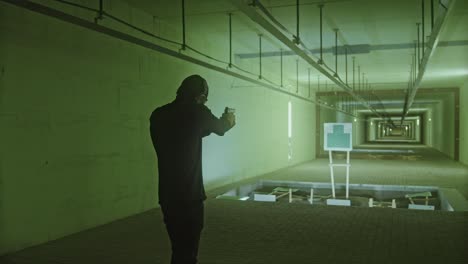 Man-during-a-shooting-practice,-adult-practicing-his-shooting-skills-on-a-target-seen-from-behind