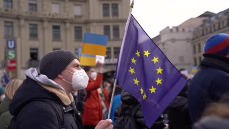 Menschen-Drücken-Ihre-Unterstützung-Für-Die-Ukraine-Bei-Einer-Anti-Kriegs-Demo-In-München-Aus,-Nachdem-Russland-In-Die-Ukraine-Einmarschiert-Ist