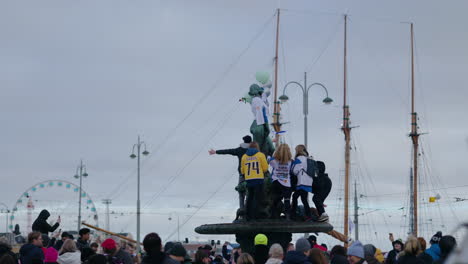 People-climbing-on-the-Havis-Amanda-statue-to-celebrate-the-ice-hockey-Olympic-gold-medal,-in-Helsinki,-Finland