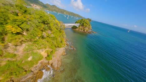 Dynamic-fpv-flight-on-the-bridges-of-the-bay-of-samana,-on-a-sunny-afternoon,-turquoise-blue-water,-catamarans-in-sight