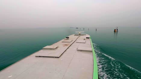 Unusual-aerial-view-of-ferry-boat-navigating-toward-Venetian-lagoon-islands,-Venice-in-Italy