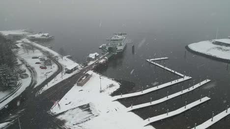 Snow-falls-as-the-Washington-State-ferry-prepares-to-load-more-commuters,-aerial