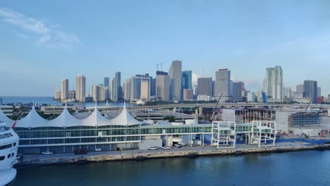 Aerial-view-of-a-cruise-port-in-front-and-Miami-downtown-cityscape-background-in-Back-video-in-4K-|-Miami-city-cruise-port-aerial-view-video-background