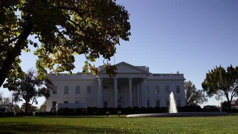 Tilt-up-motion-The-White-House-on-sunny-day-a-blue-sky,-grass-field-and-fountain