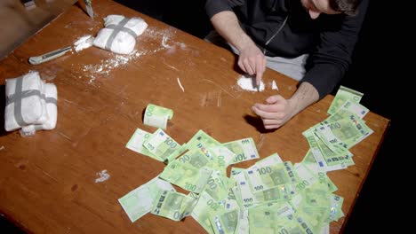 Drogendealer-Mit-Kokain-Und-Banknoten-Auf-Dem-Tisch