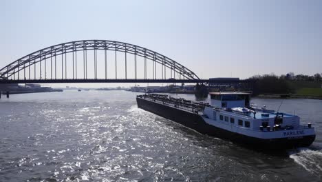 Oil-Tanker-Of-Marilene-Leaving-Backwash-On-Water-Of-River-Noord-With-Arch-Bridge-In-Front