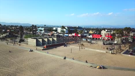 Venice-Beach,-Kalifornien,-Drohnenaufnahme,-Die-Sich-Vorwärts-Bewegt-Und-Am-Strand-über-Basketballplätze-Schwenkt,-Auf-Denen-Gebäude-Zu-Sehen-Sind