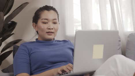 Mujer-De-Negocios-Asiática-Felizmente-Usa-Computadoras-Portátiles-Para-Trabajar-Desde-Casa-En-Línea