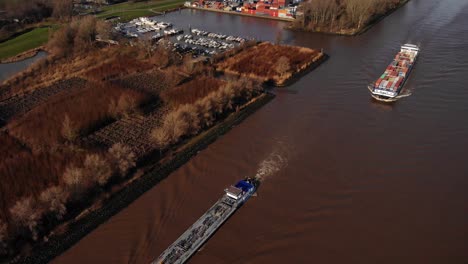 Drohnenansicht-Von-Zwei-Schiffen,-Die-Den-Yachthafen-Entlang-Des-Flusses-Noord-Passieren